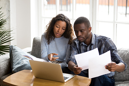 A young couple reviewing housing paperwork together