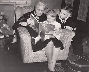 Bellford House resident with two young children reading a storybook