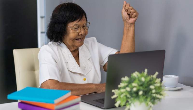 An older adult confidently using the computer