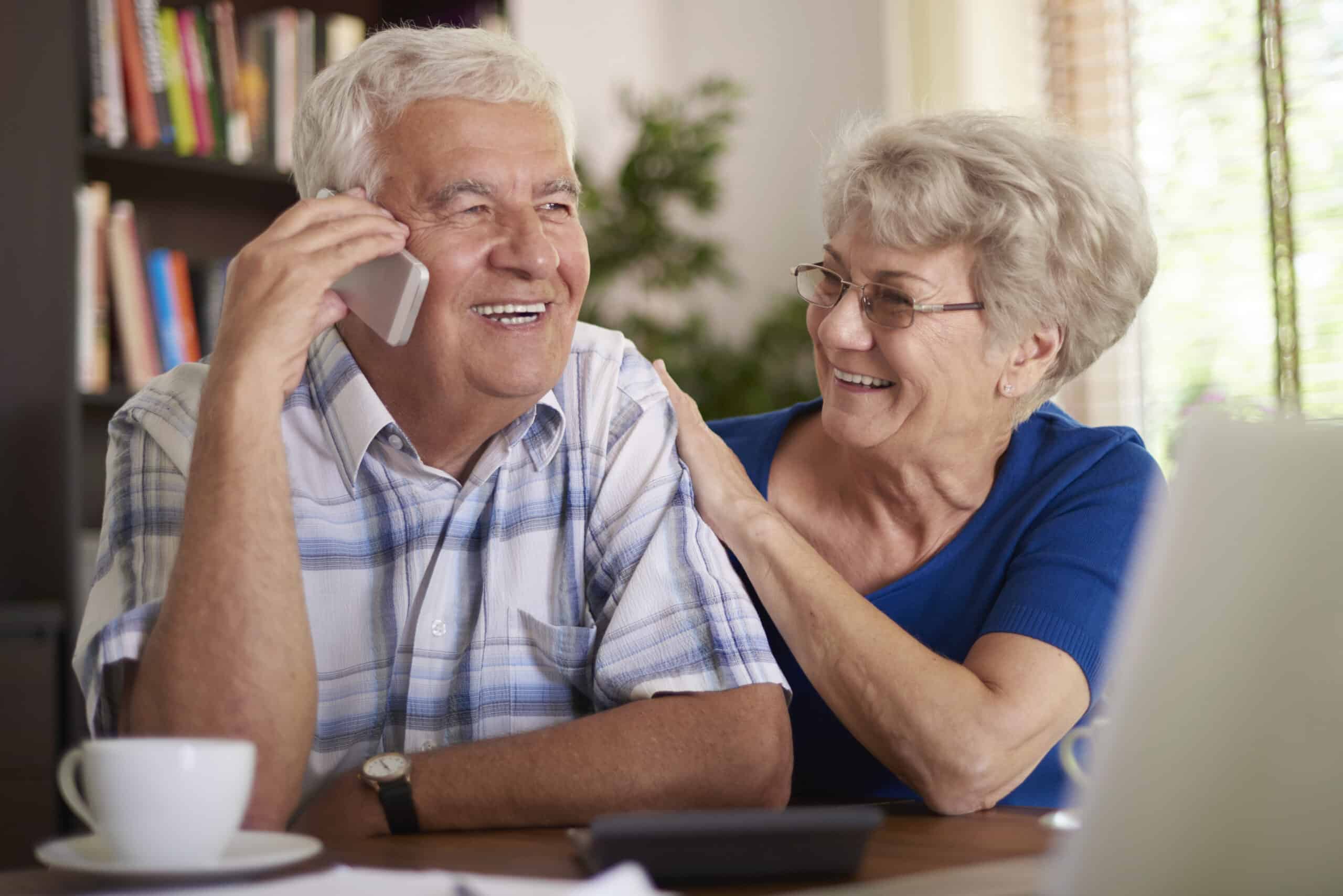 An older adult using the telephone with support from a loved one