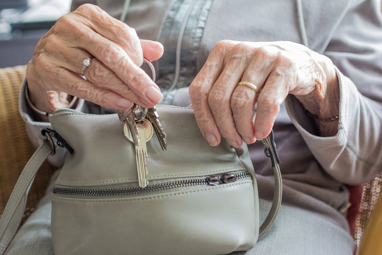 An older adult taking keys from a purse