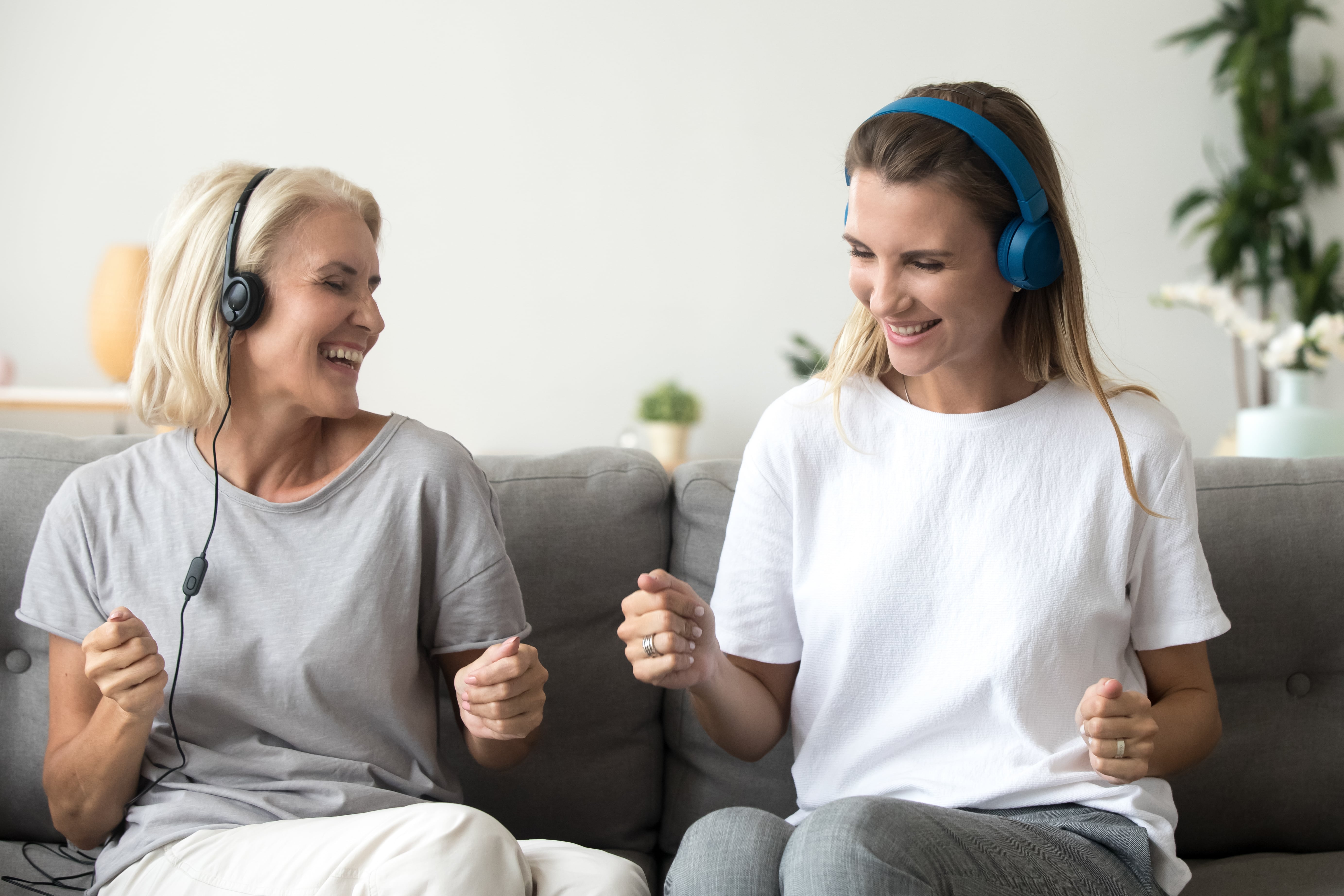 An older adult listening to music together with a caregiver