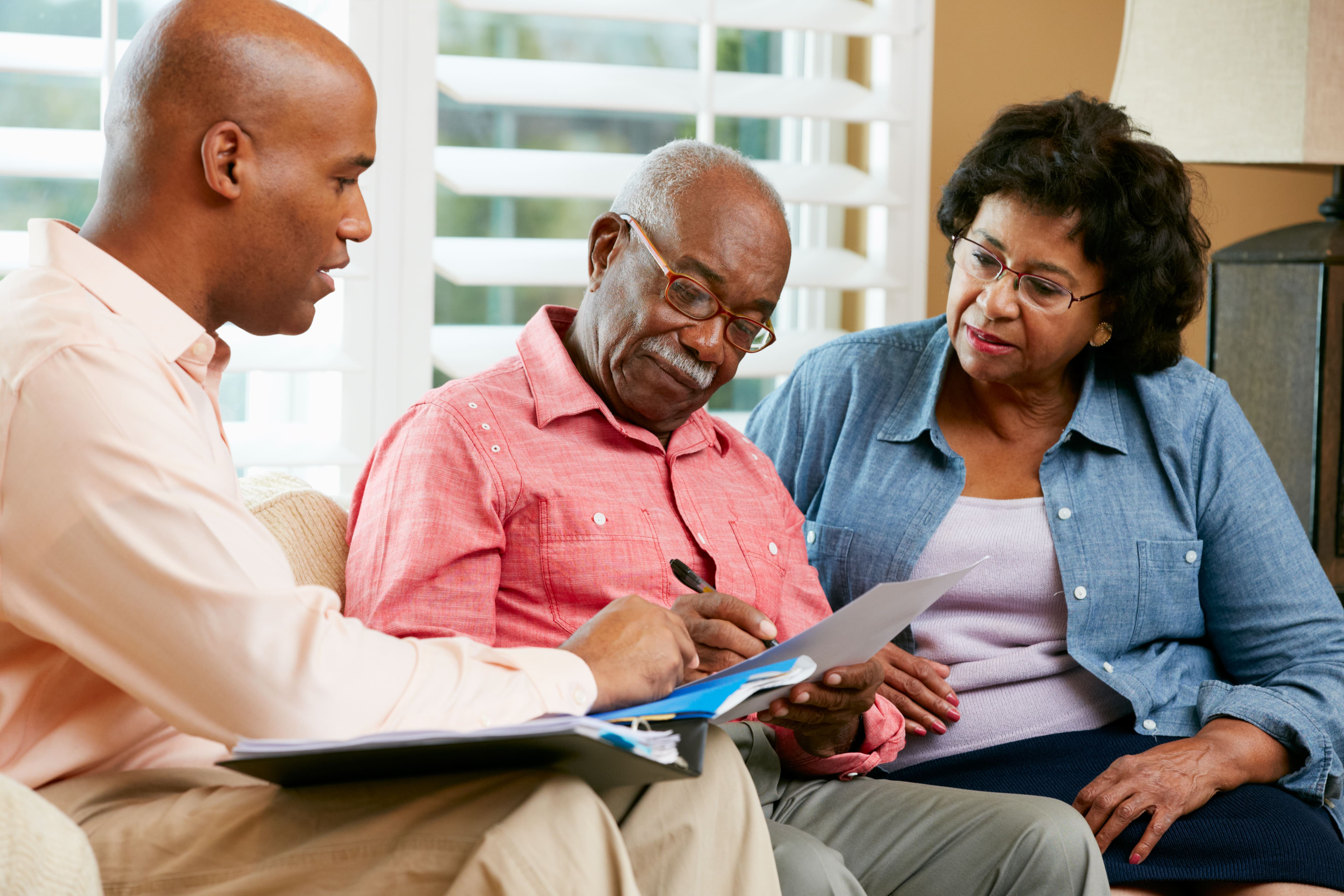 An older couple discussing legal issues with their caregiver