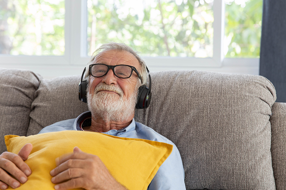 An older adult listening to music on his headphones