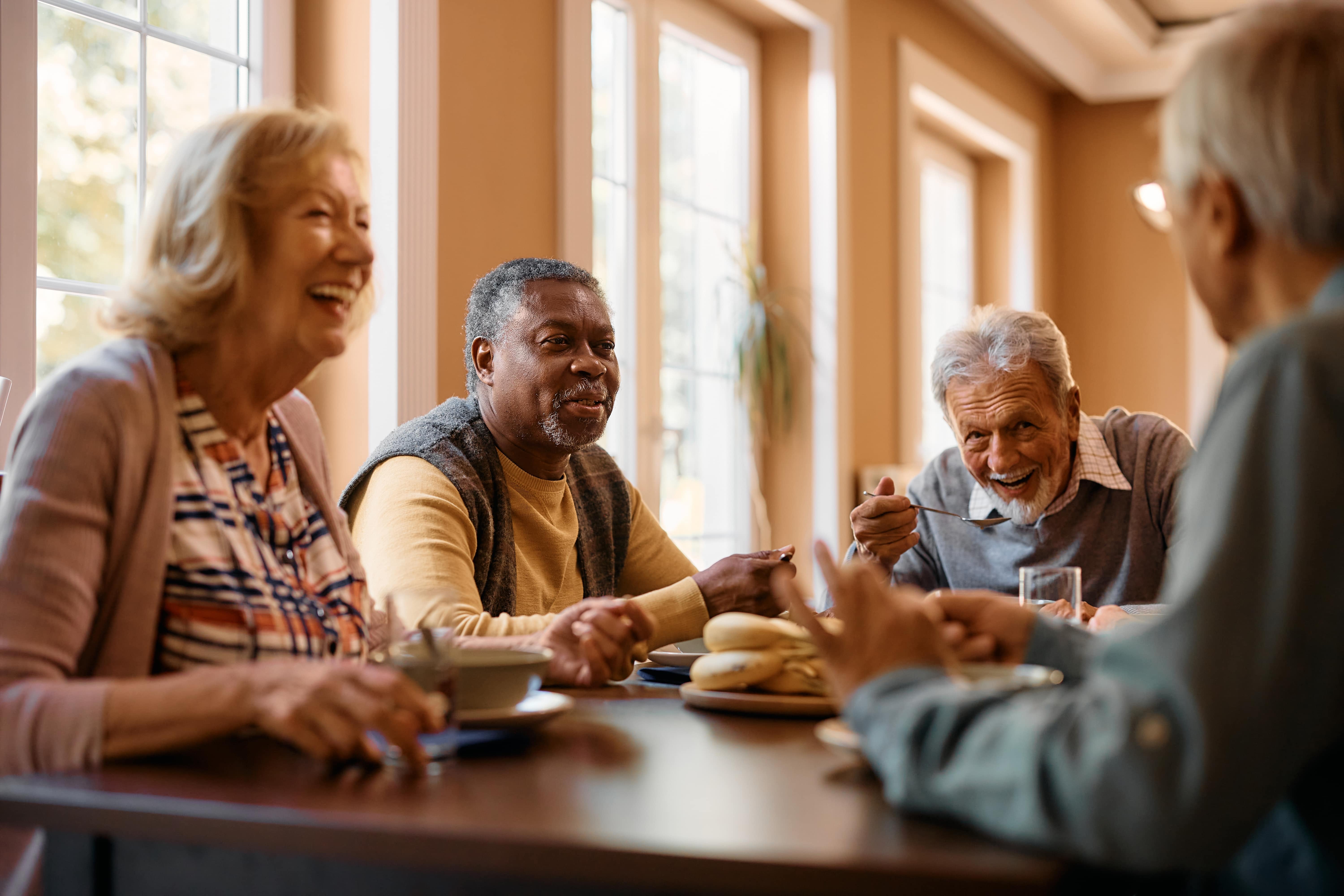 A group of older adults enjoying a conversation over a meal