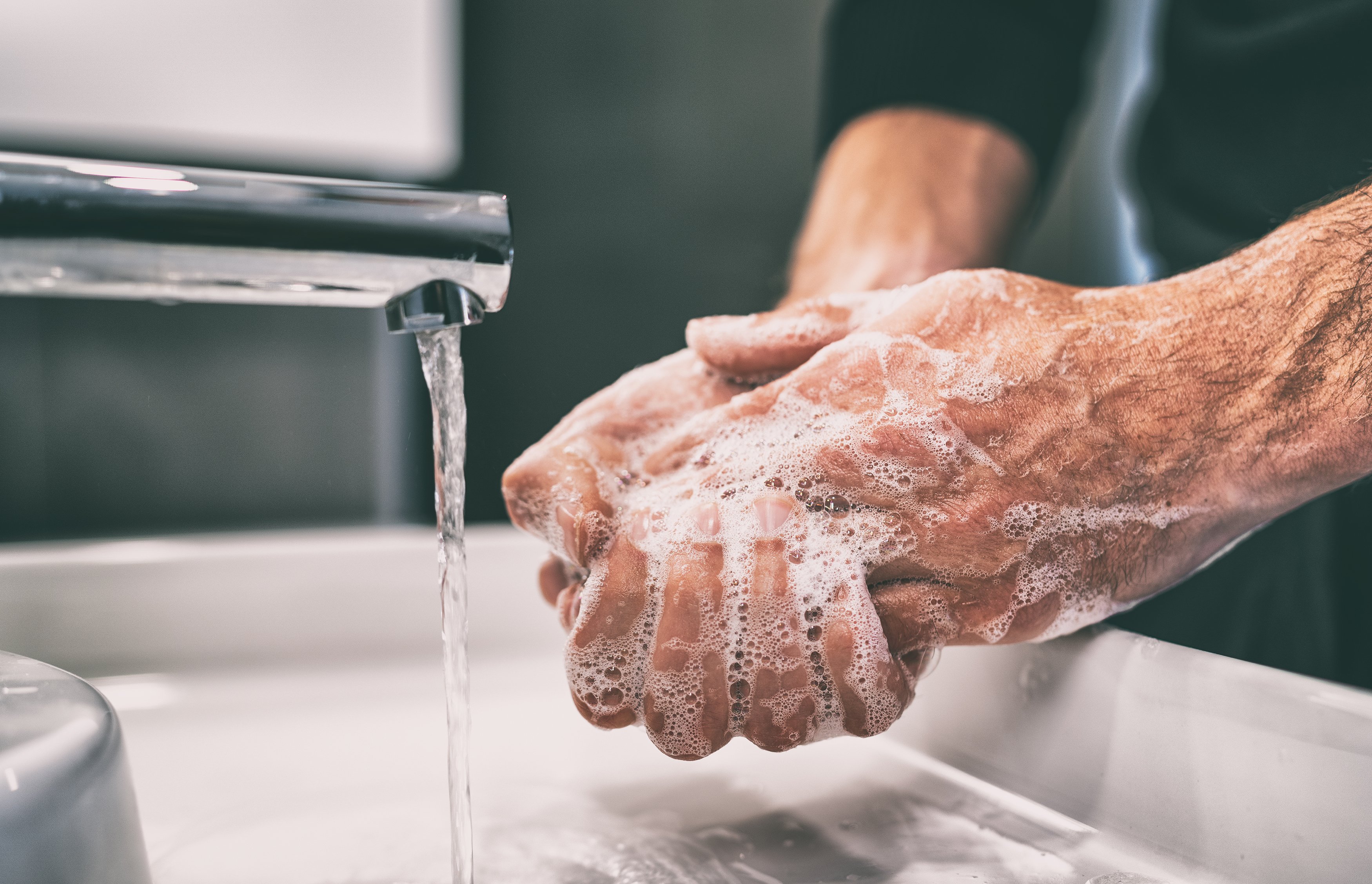 An older adult carefully washing their hands